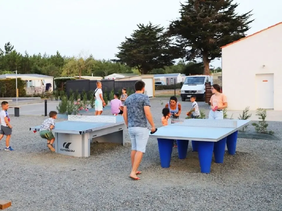 Personnes jouent au ping-pong en plein air.