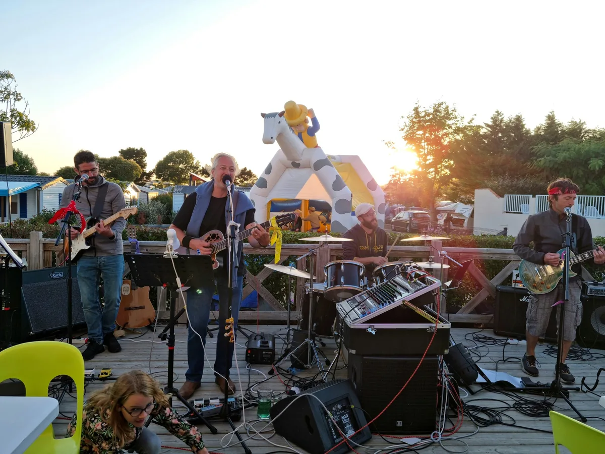 Groupe de musique jouant en plein air au crépuscule.