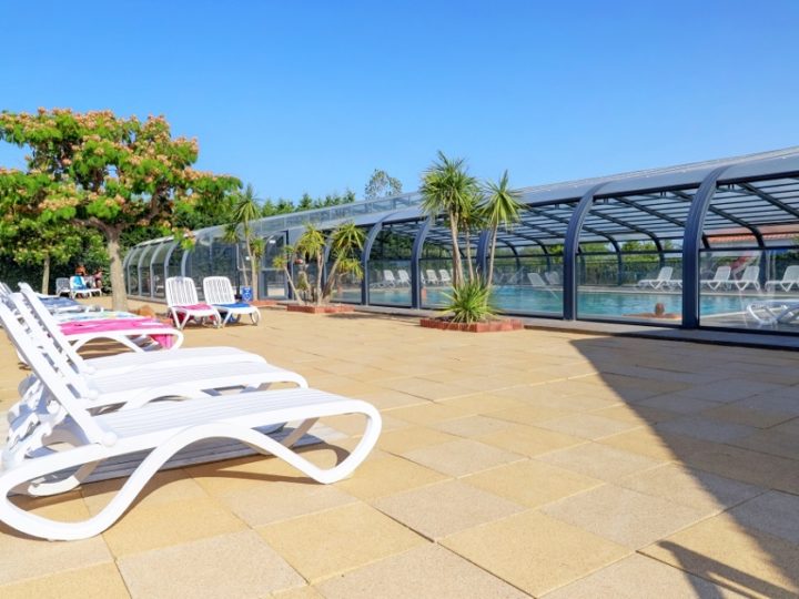 Piscine couverte avec transats blancs