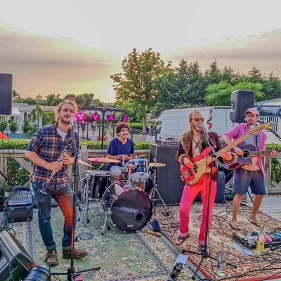 Groupe de musique jouant en plein air au crépuscule.