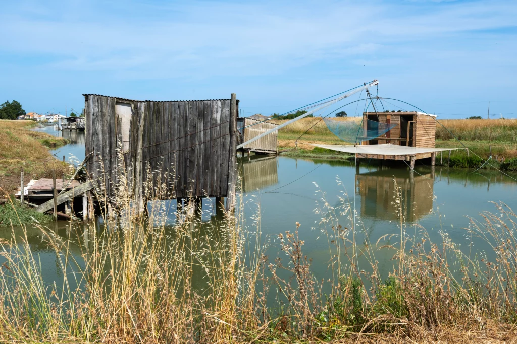 Cabanes en bois sur un étang, paysage rural.